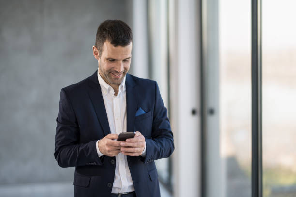 istock Happy businessman checking e-mails on phone in the office. 1471320209