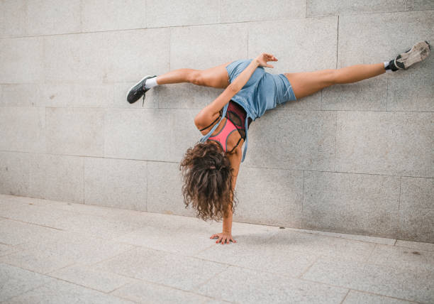 istock Female athlete does a handstand with her legs spread in a split 1471338630