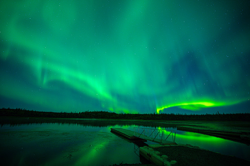 Northern Lights or aurora borealis over Sandvika beach at the Vesteralen archipelago with a starry sky in Northern Norway during a cold winter night.