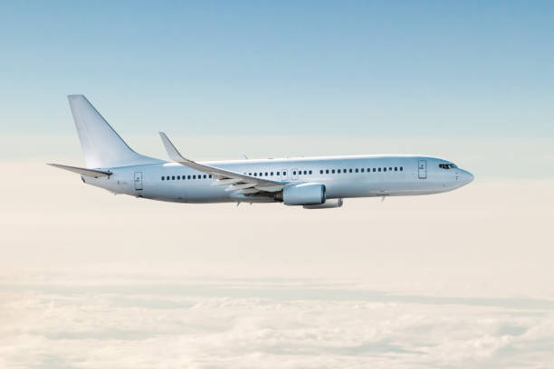 istock White passenger jet plane flies in the air above the clouds 1471348385