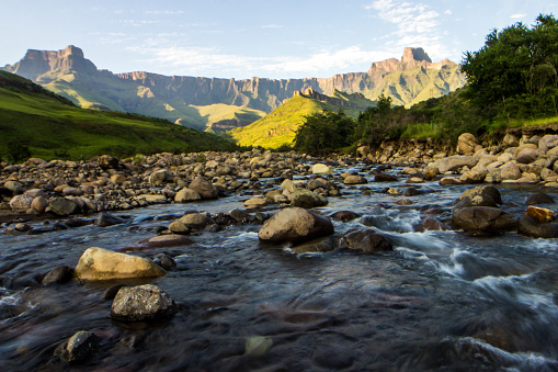 View over the Tugela river, with the majestic basalt cliffs of the Amphitheater in the background, Royal Natal national park, in the Drakensberg Mountains of South Africa. The Amphitheatre, one of the most iconic mountains of the Drakensberg and is seen as one of the most impressive cliff faces on earth. The Mountain is a 5km long crescent shaped massif with sheer basalt cliffs of up to 1 220m high and are at its highest point 3 050m above sea level.