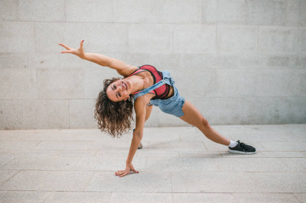 istock Woman dancer stretches her muscles through dance poses, leaning on one arm 1471353198