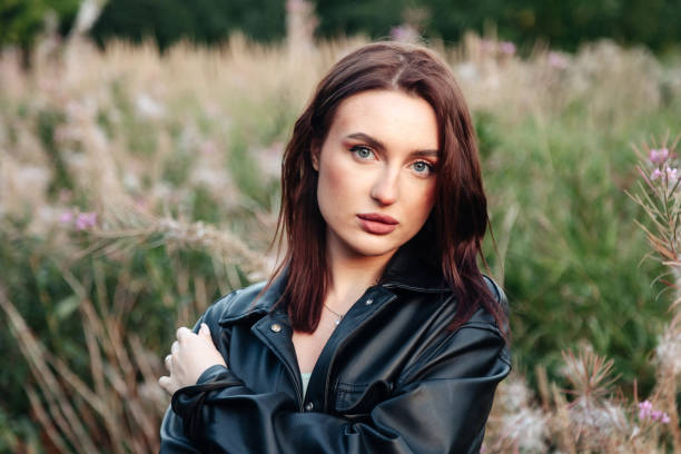 Free picture: Brunette woman standing in a field holding leather jacket ...