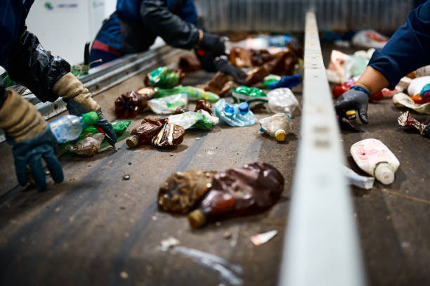 istock Worker sorts trash on conveyor belt at waste recycling plant 1471355372