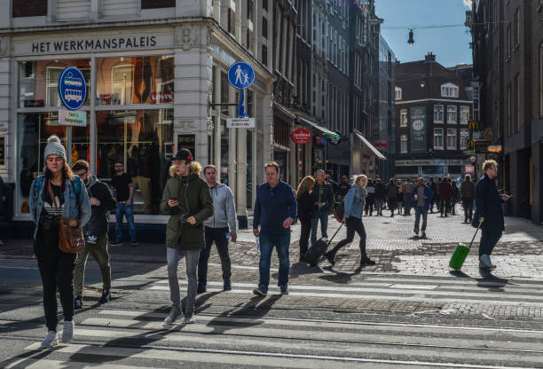 Amsterdam, Holland - Oct 7, 2018. People walking on street in downtown. Amsterdam known for its artistic heritage and narrow houses with gabled facades.
