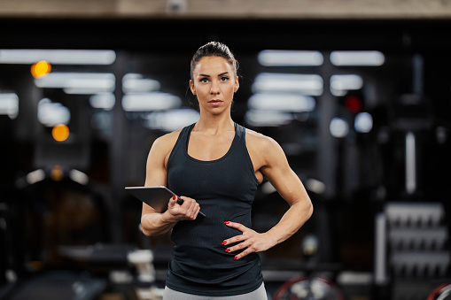 Portrait of a serious female coach with tablet in her hands looking at the camera.