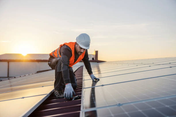 A worker is fixing solar panels on the roof.