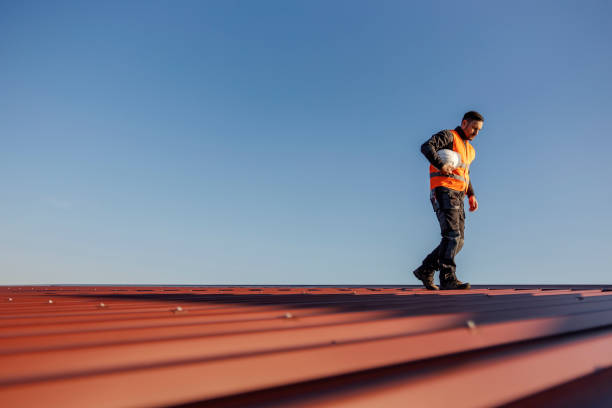A height works' worker is walking on the rooftop with helmet under armpit.