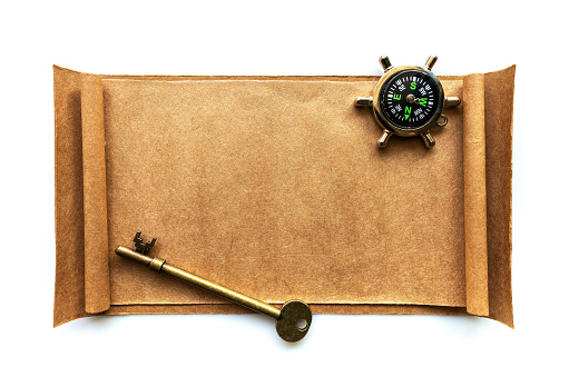 The old key and compass on brown paper isolated on white background