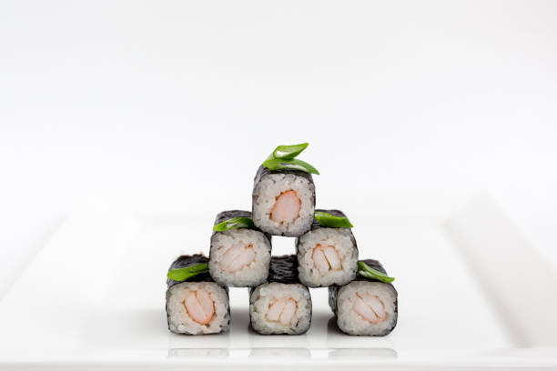 istock Sushi rolls with seafood inside wrapped in nori leaf isolated. Sushi on a plate on white background. 1471362182