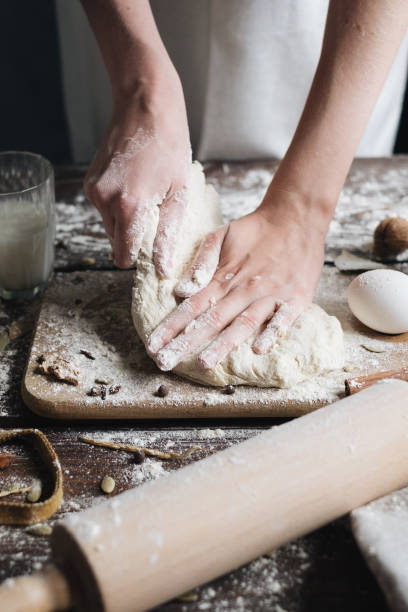 istock woman kneading fresh dough on kitchen table with flour in white cloth baker 1471363065