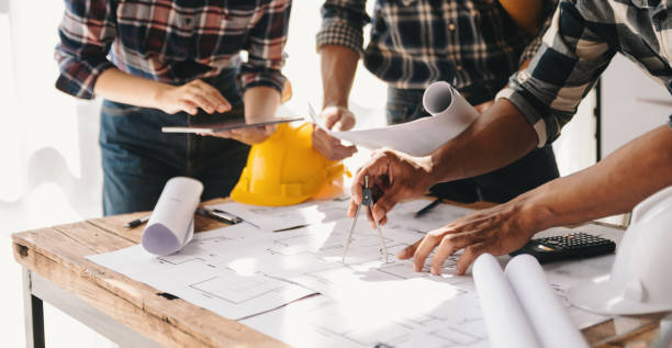 istock Engineer people meeting working in office for discussing, engineering .Hands of Engineer working on blueprint Construction concept. 1471363399