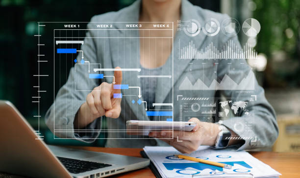 istock Businessman hand Project manager working and update tasks and Gantt chart scheduling virtual diagram.with smart phone, tablet and laptop in office. 1471363414