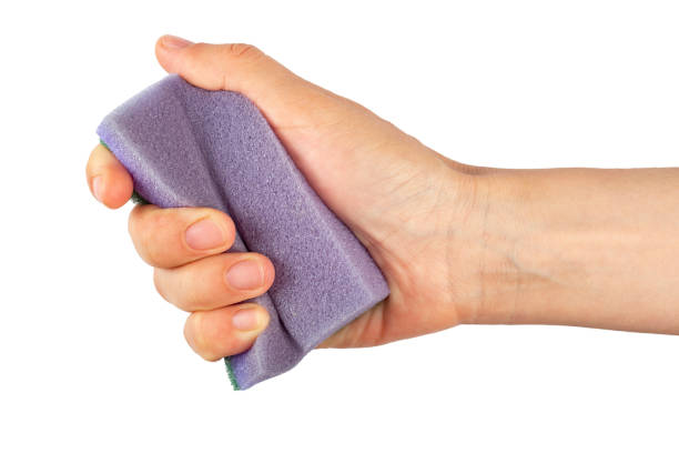 Sponge for washing and cleaning in female hand. Woman's hand gesture or sign isolated on white background. Sponge for washing and cleaning in female hand. Woman's hand gesture or sign isolated on white background. File contains clipping path. water sanitation worker washing faucet stock pictures, royalty-free photos & images