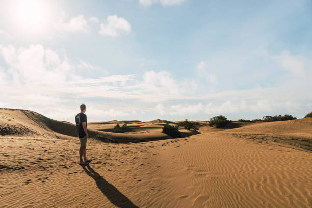 istock Man in the dunes desert in a sunny day 1471363993