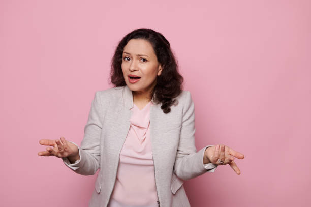 istock Disappointed woman gesturing with hands, asking what looking at camera, expressing misunderstanding on pink background 1471366442