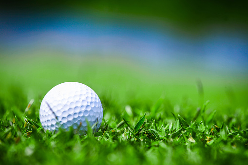 Macro of a golf ball in natural grass of golf course