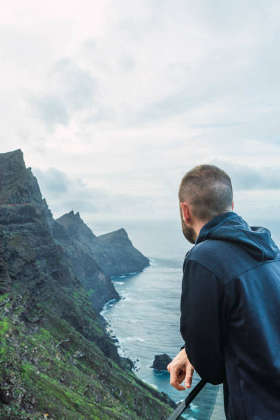 istock Man at a viewpoint watching the seascape in a cloudy day 1471373452