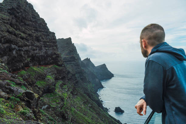istock Man on a viewpoint watching the seascape in a cloudy day 1471373486