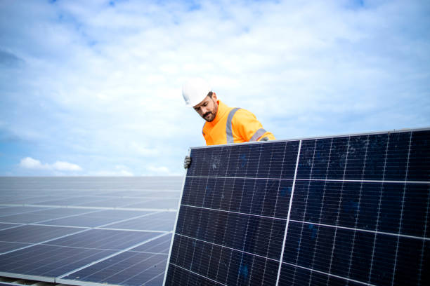 istock Installing solar power plant as sustainable energy source. Worker placing solar panel on the roof. 1471375842