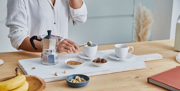 A young adult girl in the kitchen, early bird morning routine, making coffee, representing positive attitude and a healthy lifestyle, an image with a large copy space