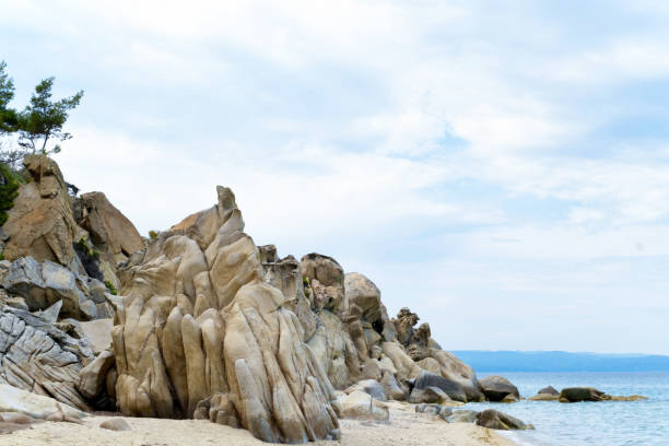 Blue sea, pine woods and white stones of Vourvourou, Fava beach Vourvourou village in Halkidiki, Aegean Sea halkidiki beach stock pictures, royalty-free photos & images