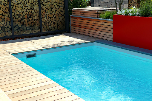 Modern swimming pool in garden on a sunny day.