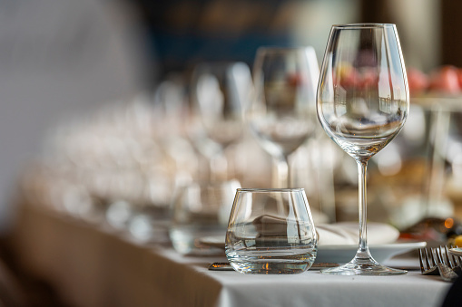 Glassware on a served table in a restaurant lined up perspective