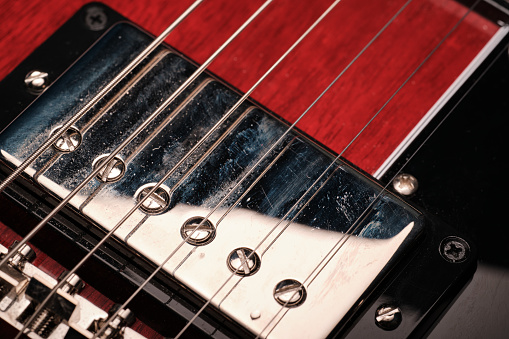 Close up guitar bass string details , four iron strings, white and black color. string instrument , electric guitar bass macro from body to neck. Music Close up. Musical instruments details