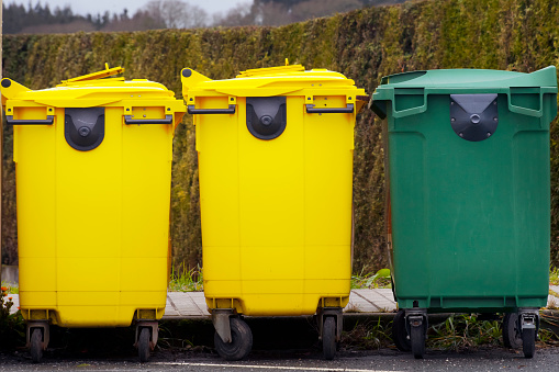 Set of a yellow and green recycling dumpsters in a row. Galicia, Spain.
