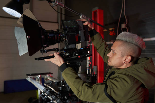 istock film set with a professional film camera installed on a camera operator's trolley and rails. caucasian videographer with hair makes a movie 1471401570