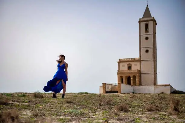 Photo of Wind of Freedom: A Woman in Blue and a Church on the Horizon