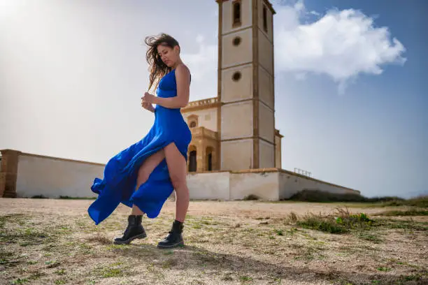 Photo of Ethereal Elegance: A Blue-Dressed Woman and a Majestic Church