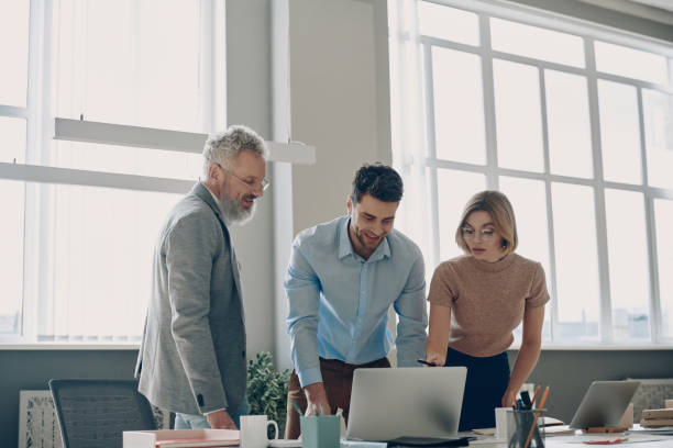 istock Three confident business people looking at laptop while working in the office together 1471405310