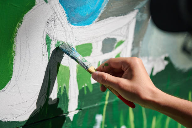 künstlerin hält pinsel und zeichnet grüne naturlandschaft auf leinwand - provincial museum stock-fotos und bilder