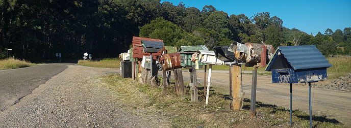 Mailbox, retro style, on country road. Rusty letterbox. Creative mailboxes in Australia. Rural road. Panoramic view.