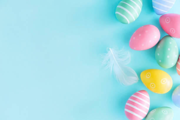 istock Top view set of various colorful easter eggs with white feather on isolated pastel blue background with copy space. Easter background concept 1471412510