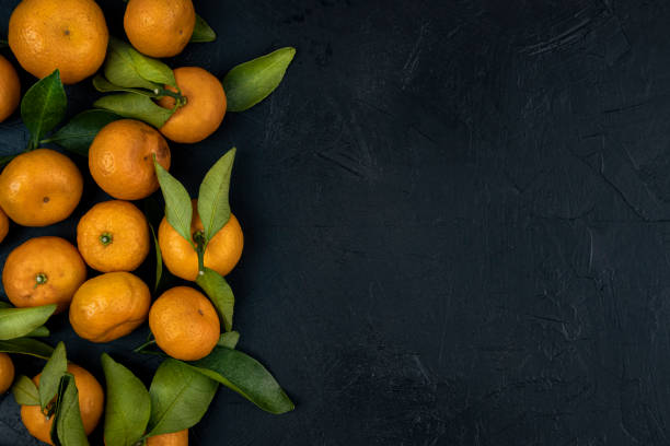 istock Tangerines on black top view, fresh juicy tangerines, flat lay, copy space. 1471412822