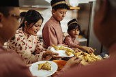 Muslim family celebrating Eid al-Fitr, couple with kids eating festive food