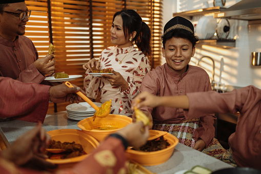 Muslim family celebrating Eid al-Fitr in hari raya attires