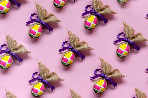 Painted easter eggs in a row on pink background