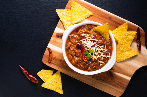 Chili with Kidney Beans, Sour Cream, Cheddar Cheese, Green Onions and Corn Chips