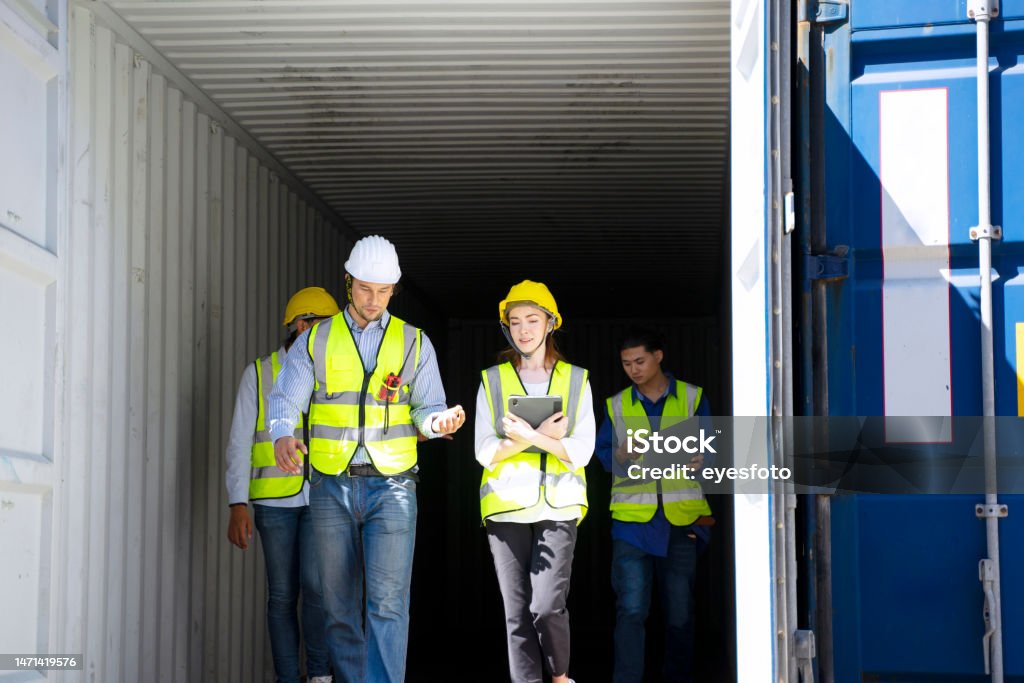 Worker work at container warehouse. Worker work at container warehouse. Blue collar worker and logistic concept. Solar Energy Stock Photo