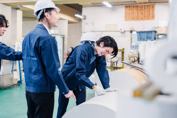 istock Workers checking paper rolls at a printing plant 1471421389