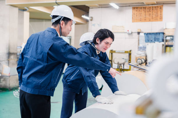 istock Workers checking paper rolls at a printing plant 1471421393