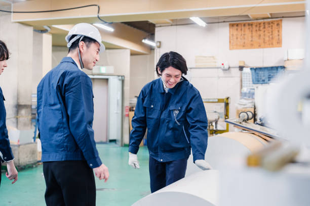 istock Workers checking paper rolls at a printing plant 1471421397