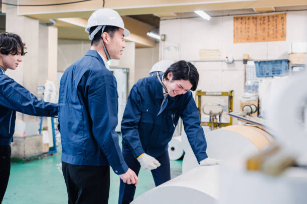 istock Workers checking paper rolls at a printing plant 1471421400