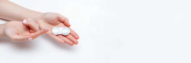 contact eye lenses. woman hands holding contact eye lens. woman hands holding white eye lens container. beautiful woman fingers holding eye lens box. health and eye care concept. high resolution. place for your text - lens contact lens glasses transparent imagens e fotografias de stock