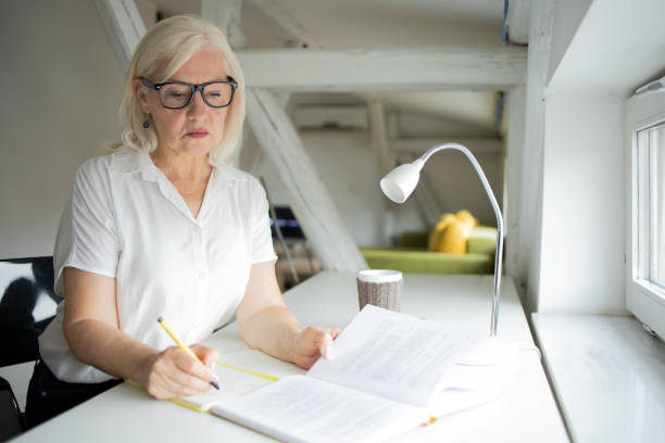 istock Happy woman reading book at home 1471421768