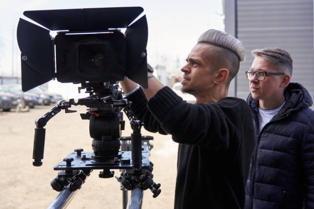 istock two caucasian men installed a large professional camera and on a camera trolley with wheels on rails and set it up 1471423433